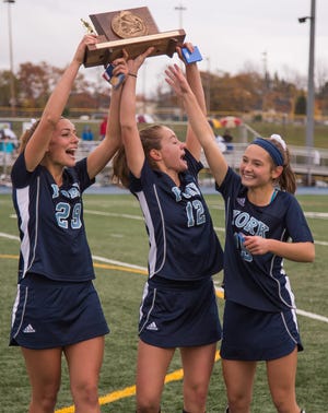 York seniors, from left, Lily Posternak, Allie Lawlor and Izzy Bretz hoist the Class B state championship trophy after beating Belfast in last month's title game at McCann Field in Bath. Christopher Lambert photo