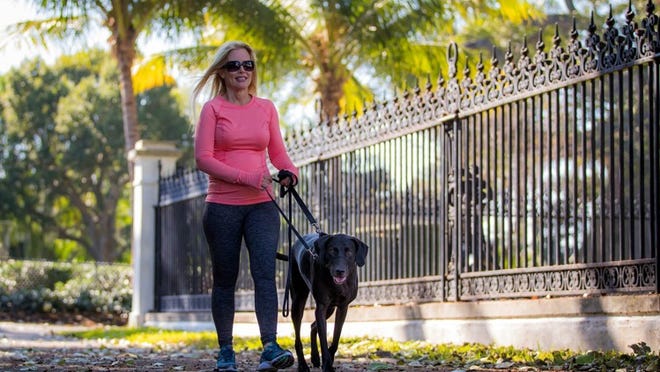 Sue Beattie and Luke take a stroll in Palm Beach. Her books about the rescue dog all include an adventure that starts with an intriguing piece of jewelry.Allen Eyestone / The Palm Beach Post