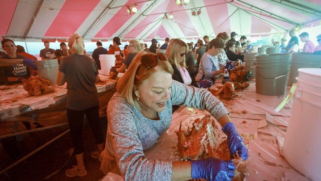 Big Heart Brigade volunteers — including Paj Mariani of Palm Beach Gardens —prepped and packaged food in Palm Beach Gardens Tuesday, November 22, 2016 for 75,000 meals that will be distributed on Thanksgiving. Mariani was pulling turkey in the Turkey Tent. “There are about 200 - 250 volunteers here now,” said Becky Kyle, Director of Life Missions with Christ Fellowship. “There will be about 400 tonight and about 5000 over the course of the week. We will finish up tomorrow night.” Each year the Thanksgiving Feast brings together thousands of volunteers from throughout South Florida who work to prepare and distribute individually packaged Thanksgiving meals. Since its founding, the 501(c)(3) non-profit organization Big Heart Brigade has fed over 1.5 million people. (Bruce R. Bennett / The Palm Beach Post)