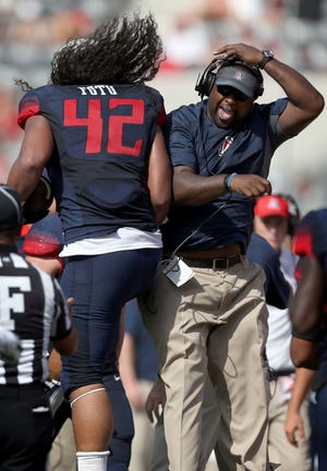 Arizona defensive line coach Vince Amey and defensive lineman Anthony Fotu celebrate Fotu’s interception against Oregon State. “As a player,” Amey said, “I had some of the best times of my life at ASU.”