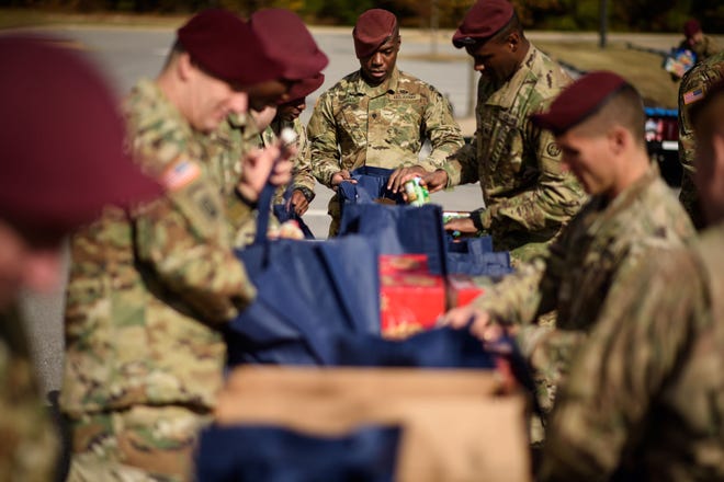Spc. Aaron Thomas, center, and his fellow paratroopers with the 82nd Airborne Division help load up bags of food that will be given out to military families in need on Tuesday, Nov. 22, 2016, at the All-American Chapel on Fort Bragg. The 82nd Airborne Division Association is partnering with Fort Bragg chaplains to provide 500 Thanksgiving meals to military families in need.