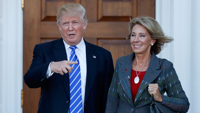 In this Nov. 19, 2016 photo, President-elect Donald Trump and Betsy DeVos pose for photographs at Trump National Golf Club Bedminster clubhouse in Bedminster, N.J. (Carolyn Kaster/Associated Press)