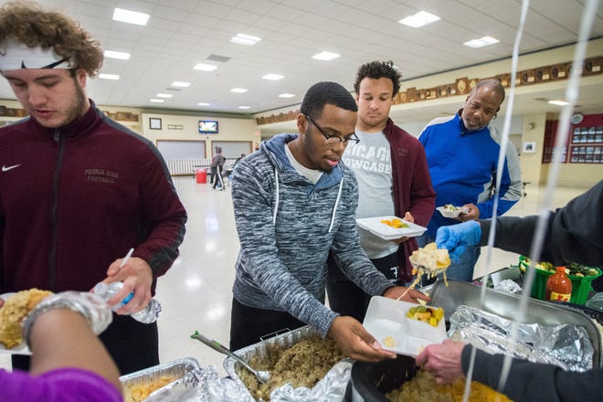 FRED ZWICKY/JOURNAL STAR The statebound Peoria High School Lions football team family gather together for a Thanksgiving feast at the school Wednesday afternoon.