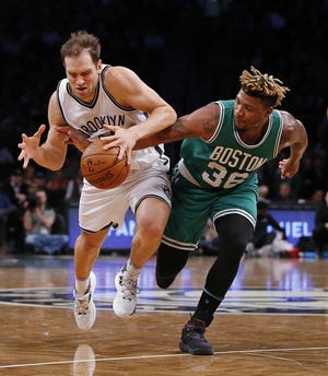 New Jersey Nets guard Bojan Bogdanovic, left, fights off Boston Celtics guard Marcus Smart (36) as he attempts to keep possession of the ball during the first half of an NBA basketball game in New York, Wednesday, Nov. 23, 2016. (AP Photo/Rich Schultz)