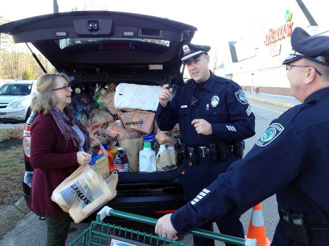 State Rep.-elect Debra Altschiller helps Stratham Police Patrol Sgt. John Emerson and Chief John Scippa Saturday during the Stratham Police Department's Holiday Food Drive to benefit the St. Vincent De Paul Center in Exeter. The event was held at Shaw's Supermarket. Courtesy photo.