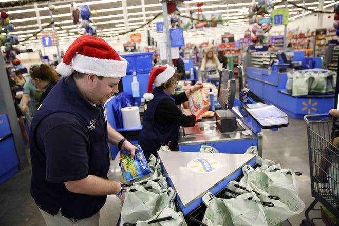An employee places an item into a shopping bag at a Wal-Mart in Burbank, California, on Nov. 22, 2016.