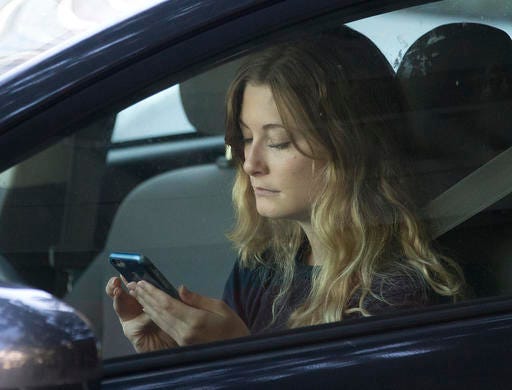 In this Wednesday, June 22, 2016, file photo, a driver uses her mobile phone while sitting in traffic in Sacramento, Calif. (AP Photo/Rich Pedroncelli, File)