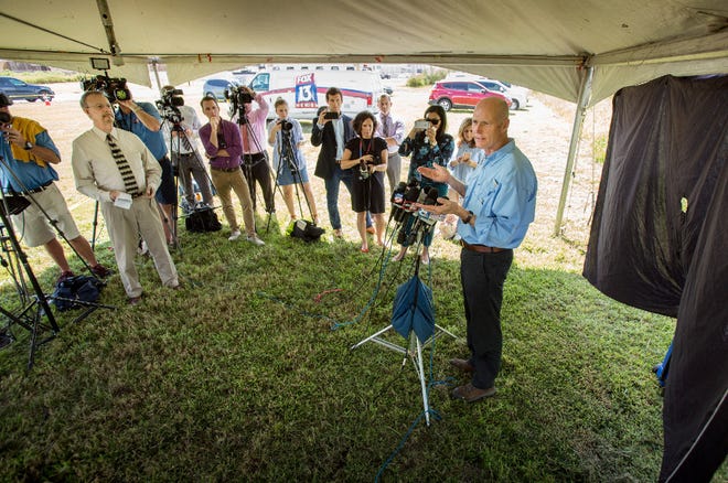 Gov. Rick Scott answers questions from the media on Sept. 27, 2016, after taking a helicopter tour of the sinkhole at the Mosaic New Wales Facility that dumped 215 million gallons of contaminated water into the Floridan aquifer in Mulberry.