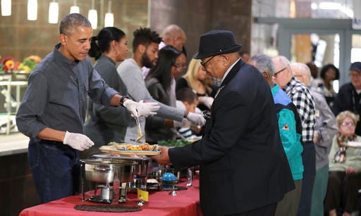 President Barack Obama, left, with first lady Michelle Obama and some relatives serve Thanksgiving meals to residents of the Armed Forces Retirement Home in Washington, Wednesday, Nov. 23, 2016. (AP Photo/Manuel Balce Ceneta)