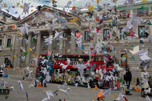 Paper birds hang on strings outside the Spanish Parliament in Madrid, Spain, Thursday, Nov. 24, 2016. Environmentalists have displayed hundreds of colored origami paper birds outside the Parliament to demand greater government action to protect Spain's Donana National Park, one of Europe's most celebrated conservation wetlands, which they say is in danger of being placed on UNESCO's endangered list due to a grave risk from excessive water extraction. (AP Photo/Paul White)