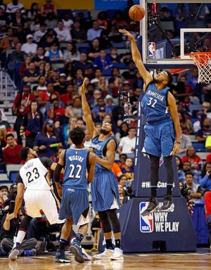 New Orleans Pelicans forward Anthony Davis (23) watches his shot over Minnesota Timberwolves forward Andrew Wiggins, forward Adreian Payne and center Karl-Anthony Towns, from left, during the first half of an NBA basketball game in New Orleans, Wednesday, Nov. 23, 2016. (AP Photo/Max Becherer)