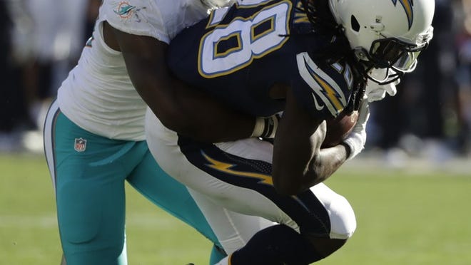 Miami Dolphins outside linebacker Neville Hewitt, left, tackles San Diego Chargers running back Melvin Gordon during the first half of an NFL football game in San Diego, Sunday, Nov. 13, 2016. (AP Photo/Gregory Bull)
