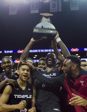 Temple's Mark Williams (10) holds the trophy as he celebrates with teammates after Friday's win over West Virginia in the final of the NIT Season Tip-Off tournament in New York. AP Photo