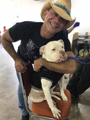 Anthony “Doc Tony” Crothers hugs a dog at a First Coast No More Homeless Pets Mega Adoption Event in Jacksonville in September 2016. The Jacksonville chiropractor financially supports many area animal rescue initiatives. (Provided by Paula Cloud)
