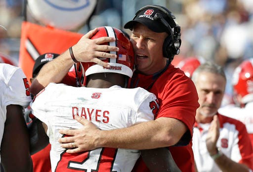 N.C. State coach Dave Doeren embraces running back Matt Dayes after one of Dayes' touchdown runs against North Carolina.