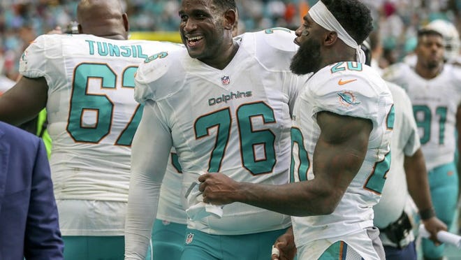 Miami Dolphins offensive tackle Branden Albert (76), celebrates along with teammate Miami Dolphins free safety Reshad Jones (20), during the final seconds against the Pittsburgh Steelers during their NFL game Sunday October 15, 2016 at Hard Rock Stadium in Miami Gardens. (Bill Ingram / The Palm Beach Post)