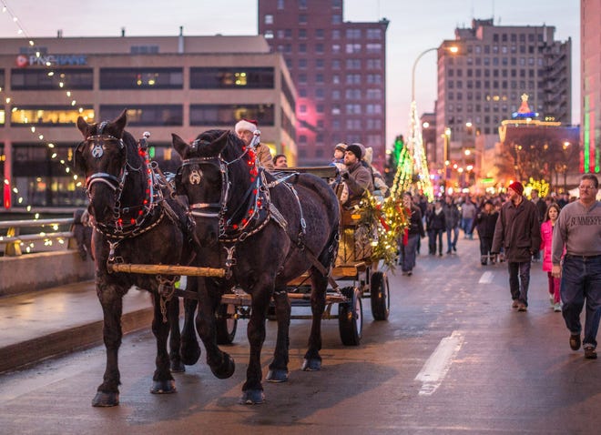 Horses pull a wagon full of people down State Street before the parade begins during the 2014 Stroll on State held in downtown Rockford. RRSTAR.COM FILE PHOTO