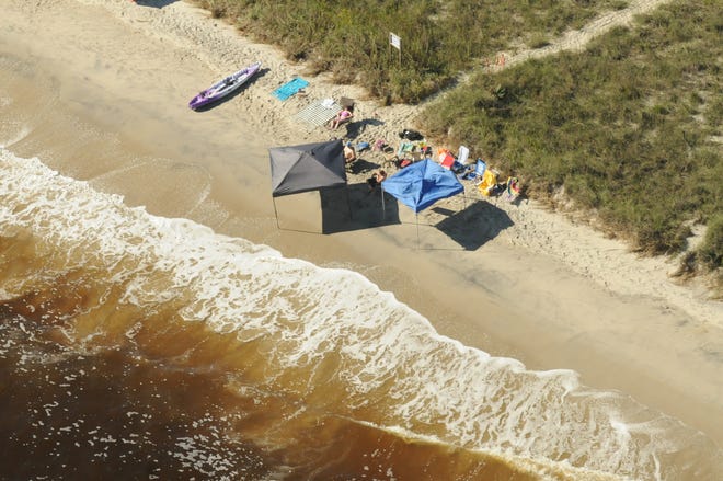Aerial photo of people enjoying the day under tents along Holden Beach in 2015. Holden Beach requires visitors to remove cabanas at sunset. StarNews file photo