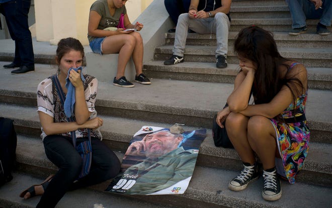Young women join a gathering one day after the death of Fidel Castro in Havana, Cuba, Saturday, Nov. 26, 2016. Cuba will observe nine days of mourning for the former president who ruled Cuba for half a century. (AP Photo/Ramon Espinosa)
