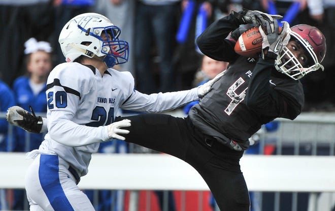 RON JOHNSON/JOURNAL STAR Central receiver Aaron Jowers pulls down a reception over Jake Morris of Vernon Hills during the IHSA Class 5A State football championship game with Vernon Hills at Champaign on Saturday.