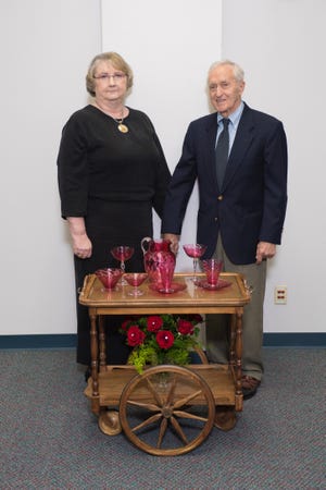 SUPPLIED PHOTO Elaine and Bob Pesch stand with the antique walnut tea cart they recently donated to Bradley University. The cart, which was given to Bob's grandmother by her employer in the 1940s, is believed to have been originally owned by Lydia Moss Bradley.