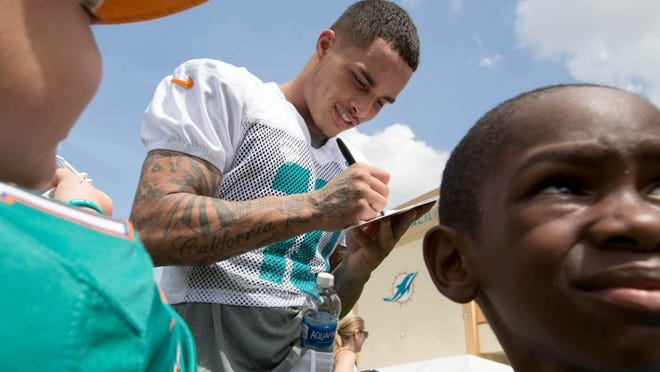 Miami Dolphins wide receiver Kenny Stills (10) signs autographs at Miami Dolphins training camp in Davie, Florida on July 29, 2016. (Allen Eyestone / The Palm Beach Post)