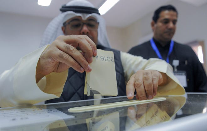A Kuwaiti man casts his ballot to choose parliamentary representatives Saturday in Kuwait City. The Associated Press