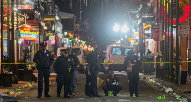 New Orleans Police Department investigators study a crime scene after a fatal shooting in New Orleans, Sunday, Nov. 27, 2016. (Matthew Hinton/The Advocate via AP)