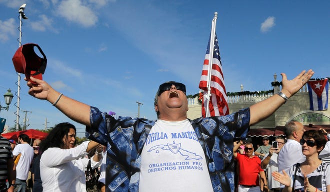 A member of the Cuban community celebrates the death of Fidel Castro, Saturday, Nov. 26, 2016, in the Little Havana area in Miami. Castro, who led a rebel army to improbable victory in Cuba, embraced Soviet-style communism and defied the power of 10 U.S. presidents during his half century rule, died at age 90. (AP Photo/Alan Diaz)
