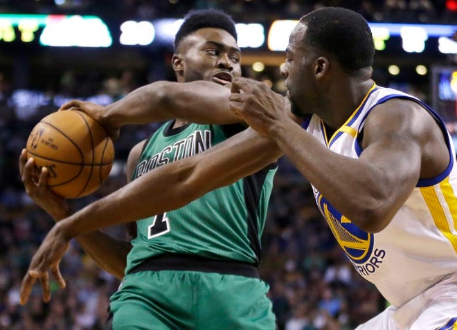Boston Celtics forward Jaylen Brown, left, looks to pass against the defense of Golden State Warriors forward Draymond Green in the first quarter of an NBA basketball game, Friday, Nov. 18, 2016, in Boston.