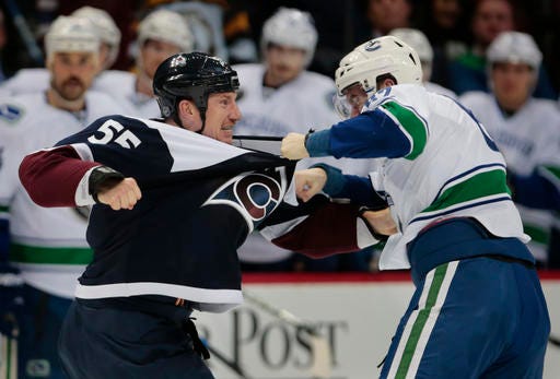 Colorado Avalanche left wing Cody McLeod (55) fights Vancouver Canucks center Joseph Labate (62) during the second period of an NHL hockey game, Saturday, Nov. 26, 2016 in Denver.(AP Photo/Joe Mahoney)