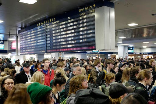 Passengers stand beneath an electronic signboard in New York's Penn Station as they wait to board a train, Sunday, Nov. 27, 2016. Millions of Americans are returning home Sundy after the long Thanksgiving weekend. (AP Photo/Mark Lennihan)