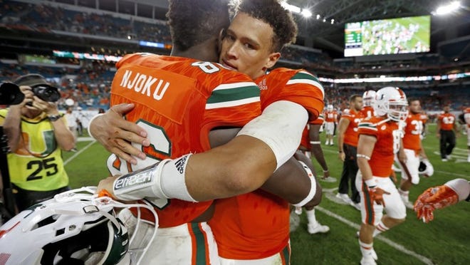 Miami tight end David Njoku (86) hugs quarterback Brad Kaaya after defeating Duke in an NCAA college football game in Miami Gardens, Fla., Saturday, Nov. 26, 2016. (Al Diaz/Miami Herald via AP)