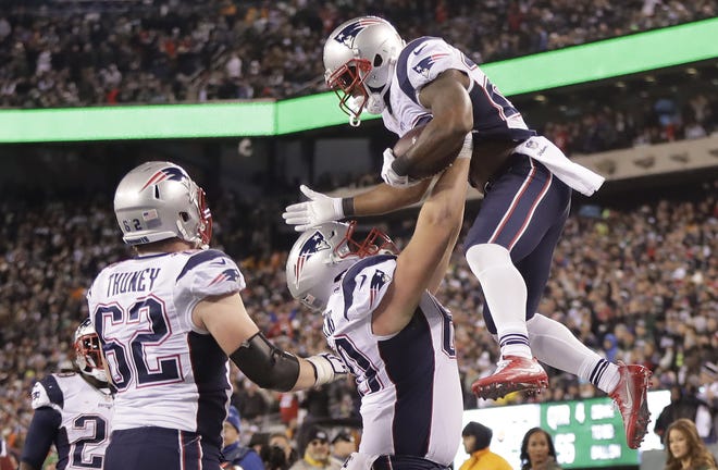 New England Patriots running back James White, right, celebrates with teammates after scoring a 2-point conversion Sunday during the Patriots' 22-17 win over the New York Jets. THE ASSOCIATED PRESS