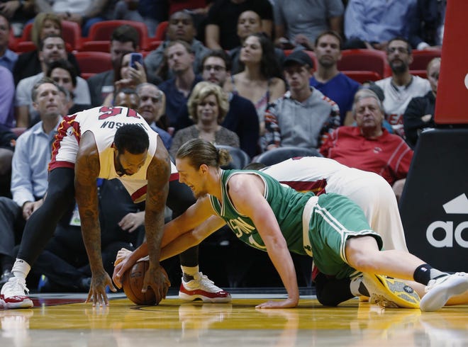 Miami Heat forwards James Johnson, left, and Josh McRoberts, rear, battle for a loose ball with Celtics forward Kelly Olynyk during Monday's game in Miami. AP Photo