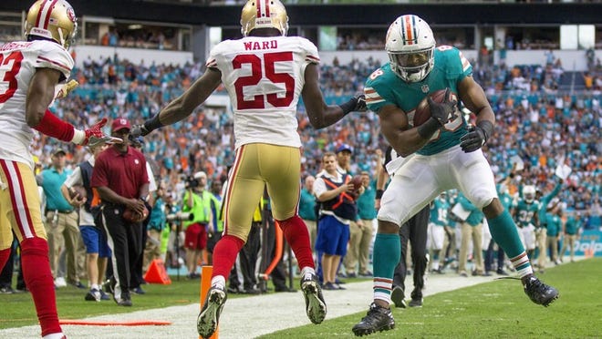 Miami Dolphins wide receiver Leonte Carroo (88), runs away from the grasp of San Francisco 49ers cornerback Jimmie Ward (25), on his way to scoring the winning touchdown of their NFL game Sunday November 27, 2016 at Hard Rock Stadium in Miami Gardens. (Bill Ingram / The Palm Beach Post)