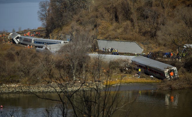 Emergency rescue personnel work the scene of a Metro-North passenger train derailment in the Bronx borough of New York, Sunday, Dec. 1, 2013. The train derailed on a curved section of track on Sunday morning, coming to rest just inches from the water and causing multiple fatalities and dozens of injuries, authorities said. Metropolitan Transportation Authority police say the train derailed near the Spuyten Duyvil station. ASSOCIATED PRESS