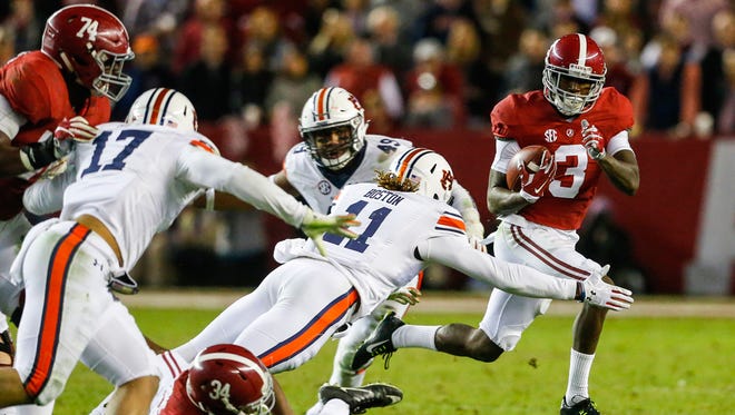 Alabama wide receiver Calvin Ridley (3) carries the ball as he tries to elude the tackle of Auburn defensive back Markell Boston (11) during the second half of the Iron Bowl NCAA college football game, Saturday, Nov. 26, 2016, in Tuscaloosa, Ala. (AP Photo/Butch Dill)