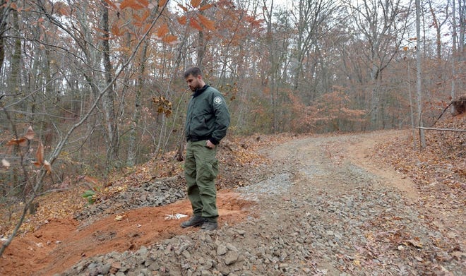 Public Information Officer Phillip Truitt checks on a water bar on a dirt road near Rumbling Bald Monday. Crews recently fixed dirt roads to allow proper water drainage and to reduce erosion.