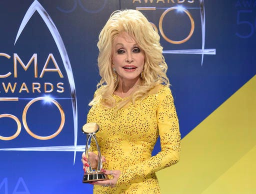 FILE - In this Nov. 2, 2016 file photo, Dolly Parton poses in the press room with the Willie Nelson Lifetime Achievement Award during the 50th annual CMA Awards in Nashville, Tenn. Parton says she’s heartbroken about wildfires that tore through the Tennessee county where she grew up, but spared the Dollywood theme park that bears her name. At least 14,000 people have been forced to evacuate the tourist area of Gatlinburg, Tennessee, and a dozen people have been injured in the wildfires. (Photo by Evan Agostini/Invision/AP, File)