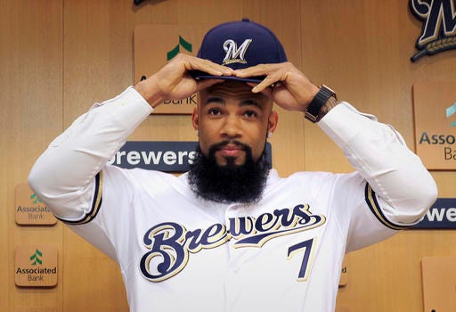 Eric Thames puts on a Milwaukee Brewers baseball cap during an introductory press conference in Milwaukee, Wisc., Tuesday, Nov. 29, 2016. The Brewers signed free agent Eric Thames, who spent the last three seasons in Korea, and designated slugging first baseman Chris Carter for assignment on Tuesday. (Rick Wood/Milwaukee Journal-Sentinel via AP)