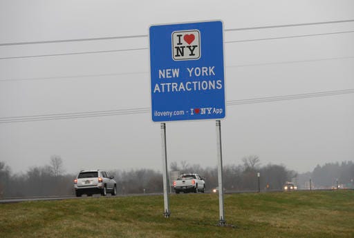 Vehicles pass an "I Love New York" sign on the New York State Thruway, Tuesday, Nov. 29, 2016, in Utica, N.Y. Officials with the Federal Highway Administration and the New York Department of Transportation will meet in December to discuss the removal of more than 500 “I Love NY” signs from the state’s roadways. FHA officials say the signs don’t conform to federal standards and pose a dangerous distraction for motorists. (AP Photo/Mike Groll)