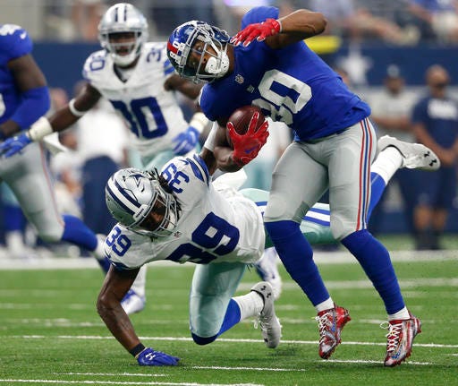 In this Sunday, Sept. 11, 2016, photo, New York Giants wide receiver Victor Cruz (80) is tackled by Dallas Cowboys cornerback Brandon Carr (39) after catching a pass during an NFL football game in Arlington, Texas. The Cowboys haven't forced a turnover in four games and couldn't get a sack of Washington's Kirk Cousins despite 53 pass attempts. After an early season surge into the top 10, the Cowboys have slid a bit. (AP Photo/Michael Ainsworth)