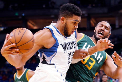 Minnesota Timberwolves' Karl-Anthony Towns, left, drives into Utah Jazz's Boris Diaw of France in the second half of an NBA basketball game Monday, Nov. 28, 2016, in Minneapolis. The Jazz won 112-103. (AP Photo/Jim Mone)