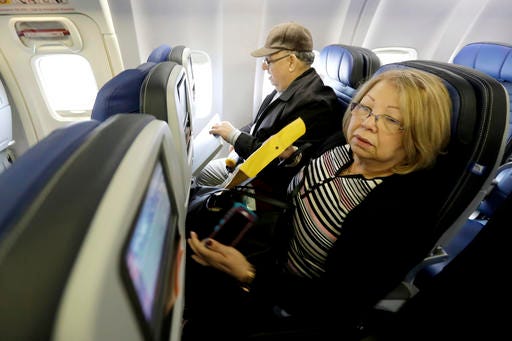 Dania Rivero, right, and her husband Jesus Rivero, of West New York, N.J., settle into their seats on United Flight 1502 the first direct passenger flight from Newark Liberty International Airport to Havana, Cuba, Tuesday, Nov. 29, 2016, in Newark, N.J. Commercial flights between the United States and Cuba resumed several months ago as relations between the two countries gradually improved under President Barack Obama. (AP Photo/Julio Cortez)
