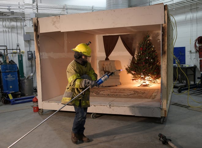 Worcester Polytechnic Institute graduate student Panyawat Tukaew lights a Christmas tree on fire during a safety demonstration at the school's fire lab Tuesday. See video at telegram.com. T&G Staff/Christine Peterson