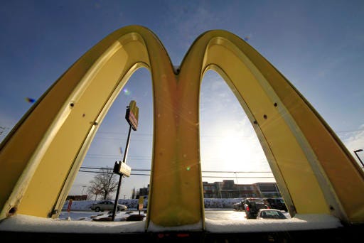 In this Jan. 21, 2014 photo, cars drive past the McDonald's Golden Arches logo at a McDonald's restaurant in Robinson Township, Pa. 
AP Photo/Gene J. Puskar, File