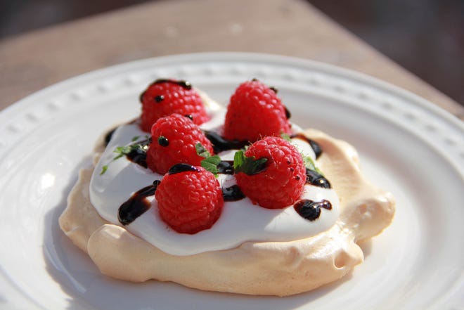 Melissa d'Arabian via AP — This Nov. 18, 2016, photo shows tangy raspberry (reduced sugar) pavlova with a balsamic glaze. For the uninitiated, a pavlova (named after the famed ballerinaâ€™s fluffy tutu) is essentially a meringue shell baked at low heat until the outside is barely golden crisp, but the inside remains soft and billowy, like a creamy marshmallow.