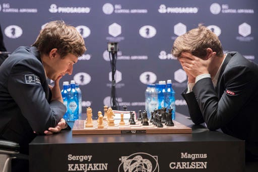 Sergey Karjakin, left, of Russia, and defending champion Magnus Carlsen, of Norway, concentrate on the board during the tie breaker round of the World Chess Championship, Wednesday, Nov. 30, 2016, in New York. (AP Photo/Mary Altaffer)