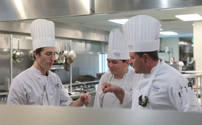 Culinary arts students fist bump after trying each others' recipes at Gulf Coast State College on Wednesday. Best Choice Schools recently named the program the third best in the state. HEATHER HOWARD/THE NEWS HERALD
